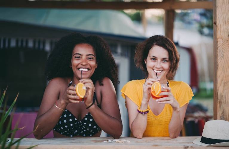 two women having drinks at a beachy bar