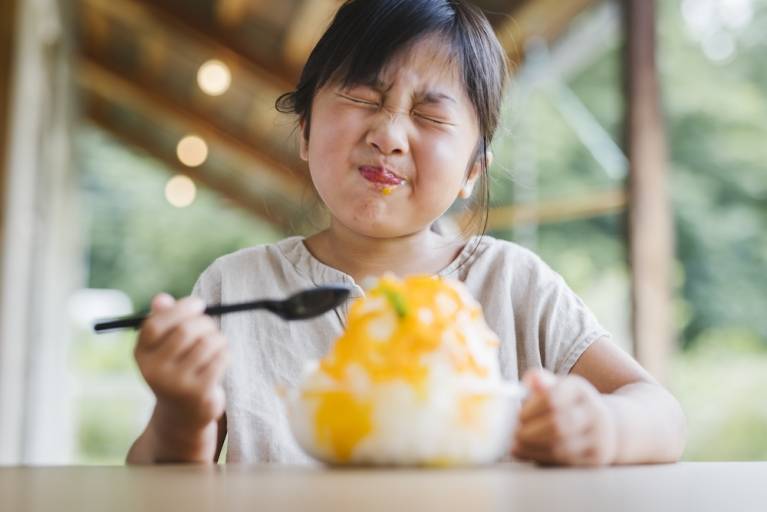 little girl eating hawaiian snack of shaved ice