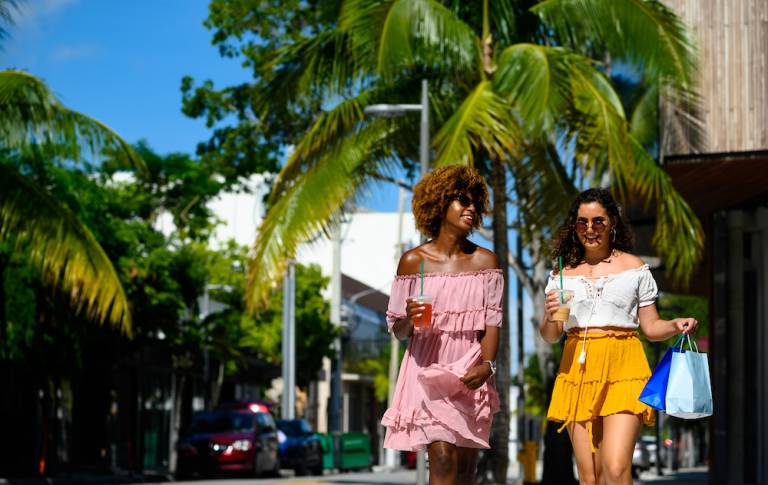 two women walking at a tropical outdoor mall 