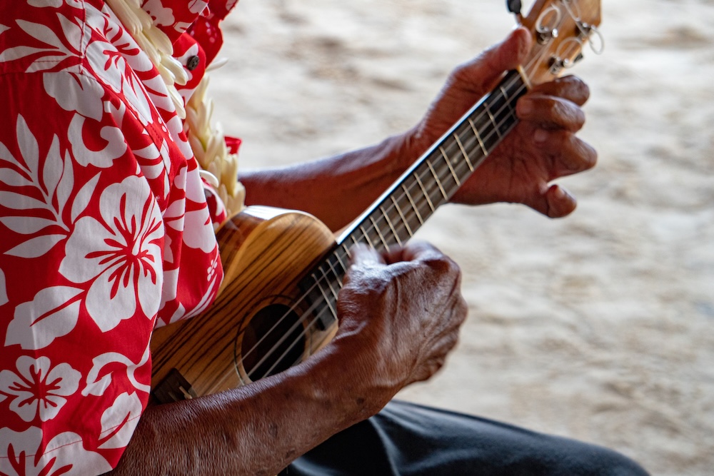 old man hands playing hukulele