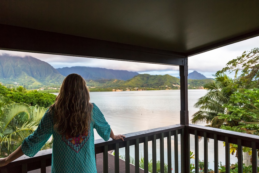 Rear view of a beautiful woman enjoying a scenic ocean view from her balcony in Hawaii.